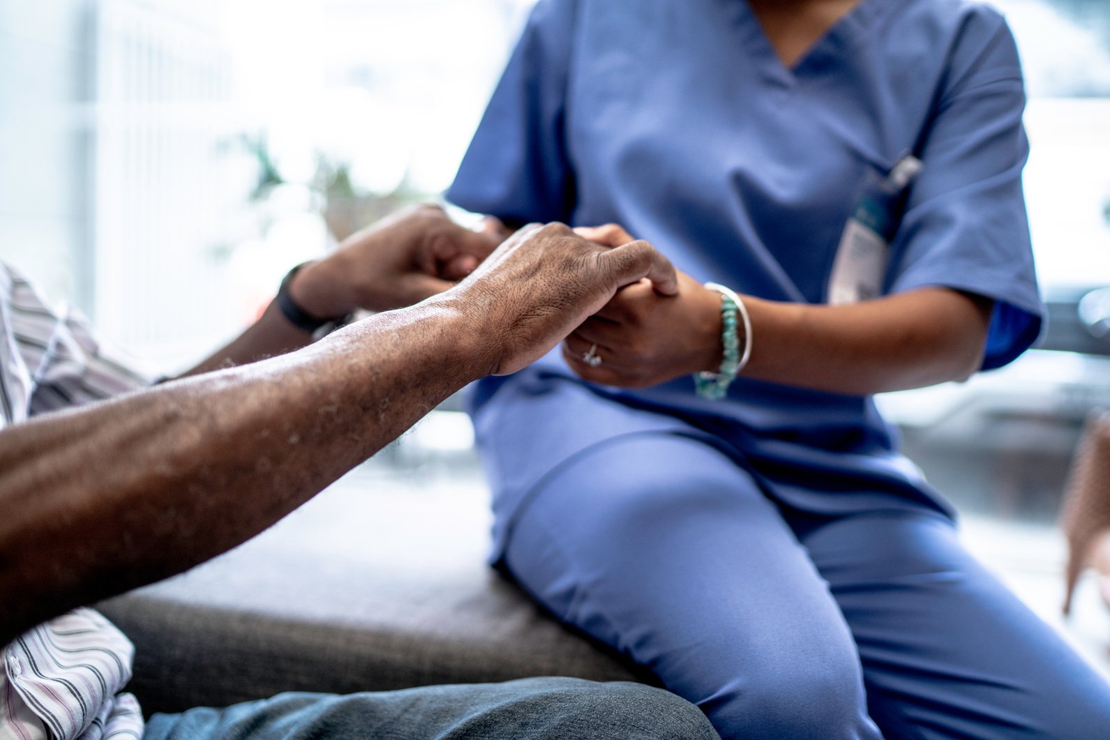 Nurse holding patient's hands